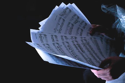 Primer pla d'unes mans subjectant una partitura.