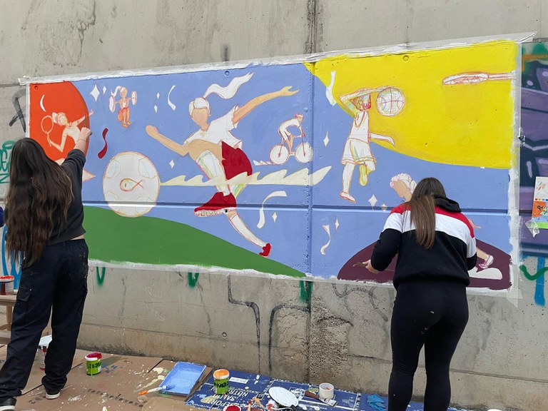 Joves realitzant una pintura mural a la ciutat