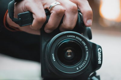 Primer plano de una mano sujetando una cámara fotográfica.