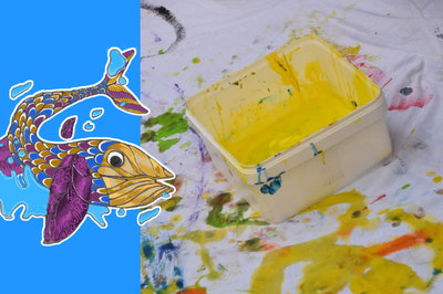 Bote con pintura sobre una tela con dibujos y manchas de color.