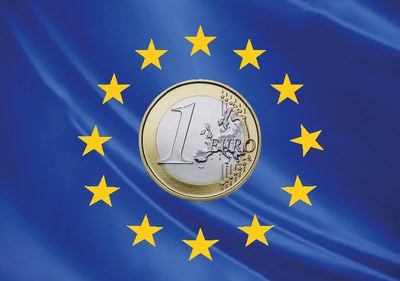 Una moneda de un euro sobre la bandera de Europa.