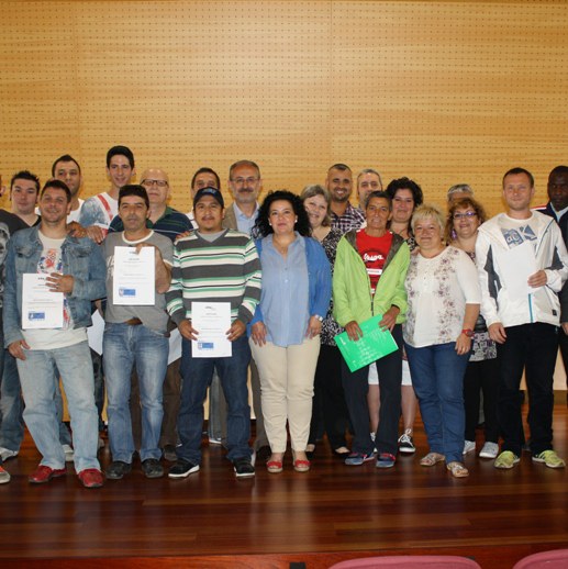 A dalt, fotografia de grup de tots els participants. A baix, l'alcalde lliura el carnet a un dels participants